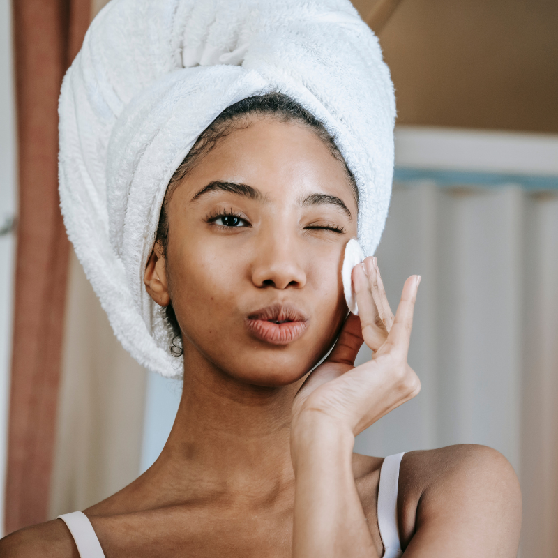 A woman in a towel gently presses a towel against her face. She follows 5 Tips for a Perfect Skin.