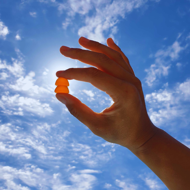 A person holding a gummy in the blue sky. Are you getting enough Vitamin D?