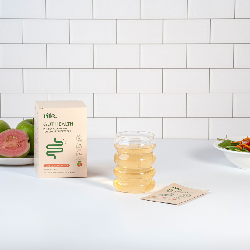 GUT HEALTH prebiotic drink mix box, sachet, and prepared drink in a clear glass, guava flavored to support digestion.