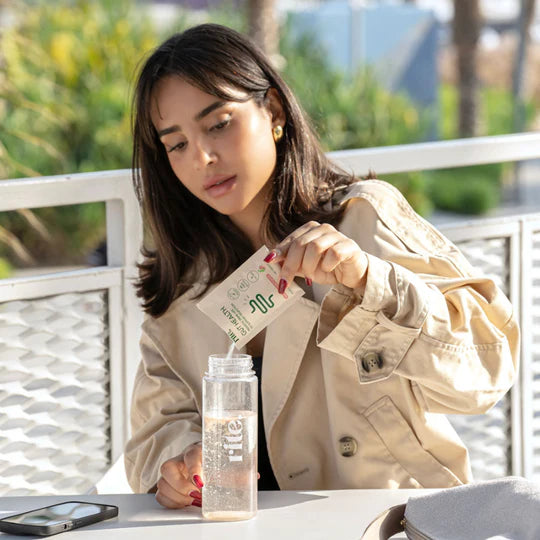 Mixing GUT HEALTH sachet into bottle to support digestion, improve gut health, and boost wellness