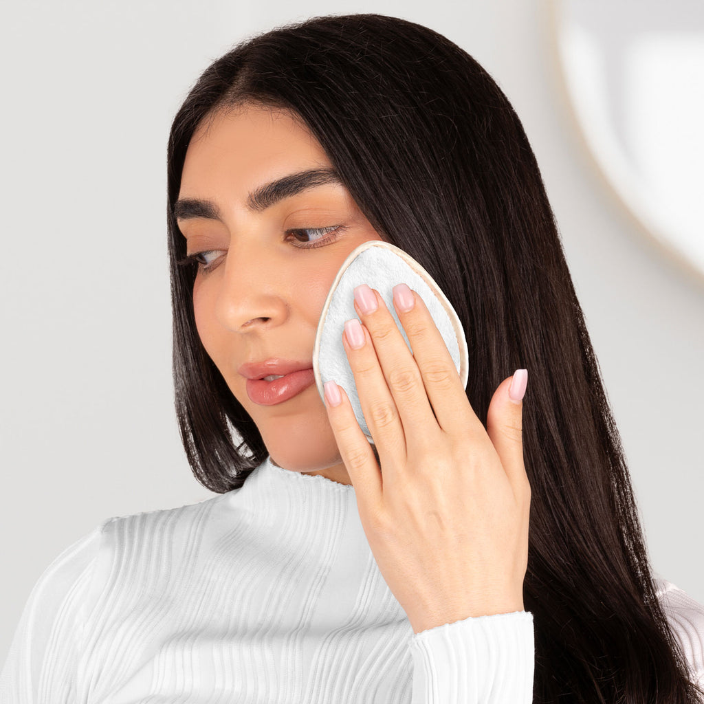 Woman cleansing face with reusable MAKEUP REMOVER PADS, a sustainable and gentle skincare essential.