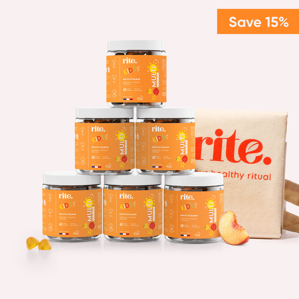 Six jars of Rite Kids Multivitamin Suagr Free Gummies stacked on top of each other with slices of peach in front of them.