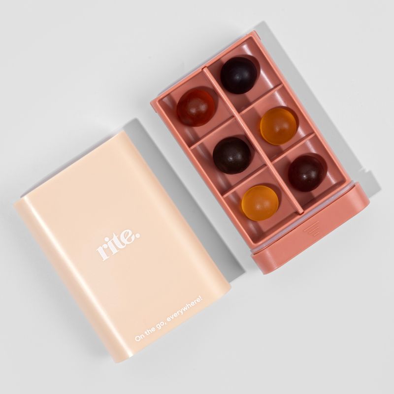 A box of gummies sits on a wooden table.The brand name "Rite" is written on the side of the box in white text.