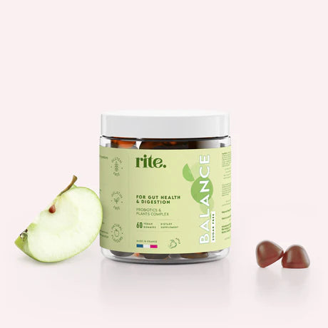 A jar of Rite Balance vegan gummies sits on a table next to a Green apple. 