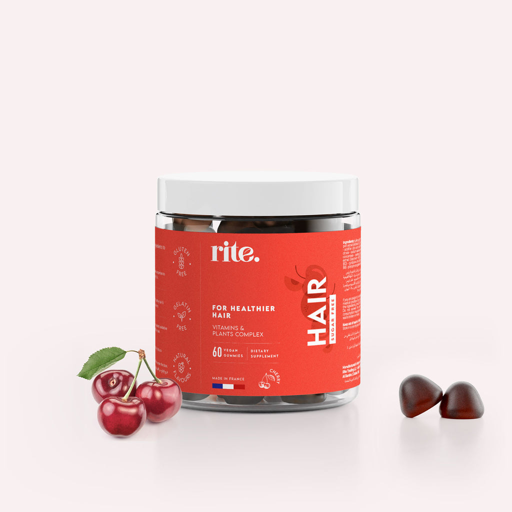 A jar of Rite Hair Gummies in the shape of cherries next to a red cherry on a white background. 