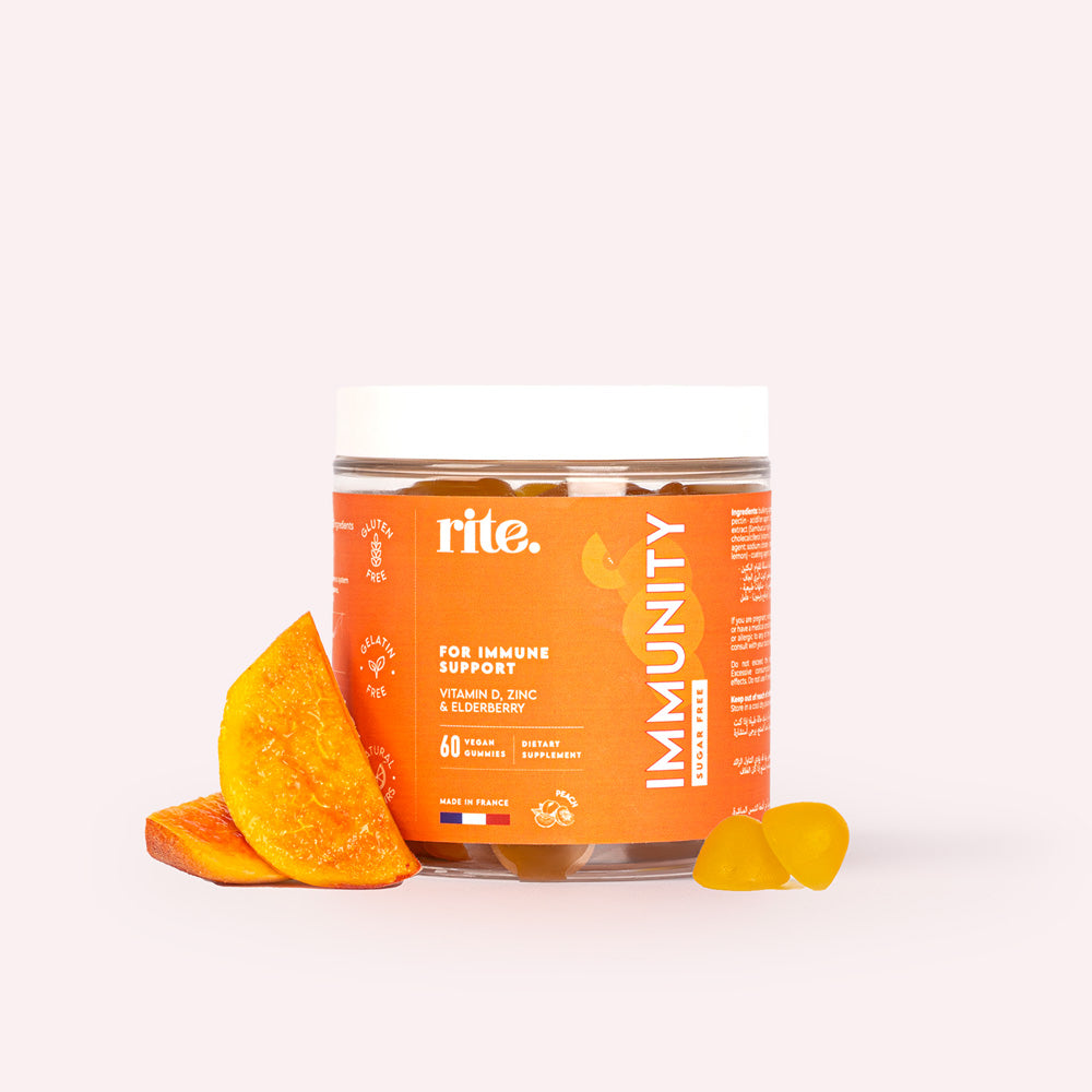 A jar of  Rite Multivitamin gummies sits next to slices of peach. 
